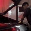 Detailing technician hand cleaning the trunk of an Audi