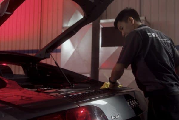 Detailing technician hand cleaning the trunk of an Audi