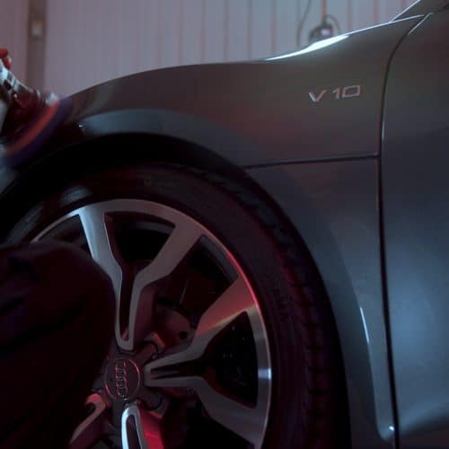 Detailing technician buffing the driver side of an Audi