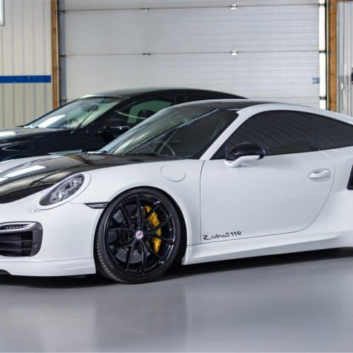 A white Porsche 911 Turbo S in the service area of RSP Motorsports